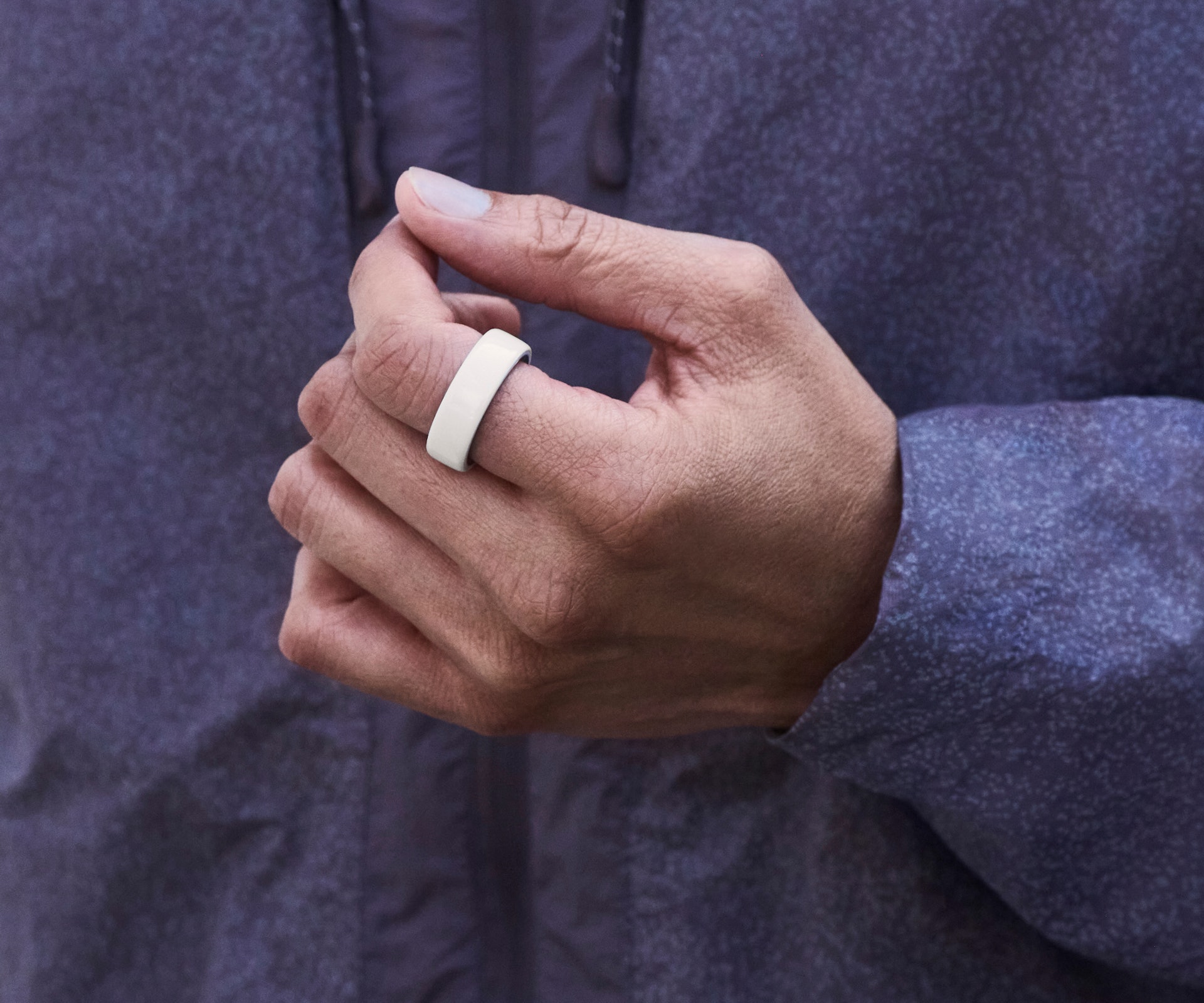 Close up of a person's hand with a Cloud Oura Ring 4 Ceramic on their finger
