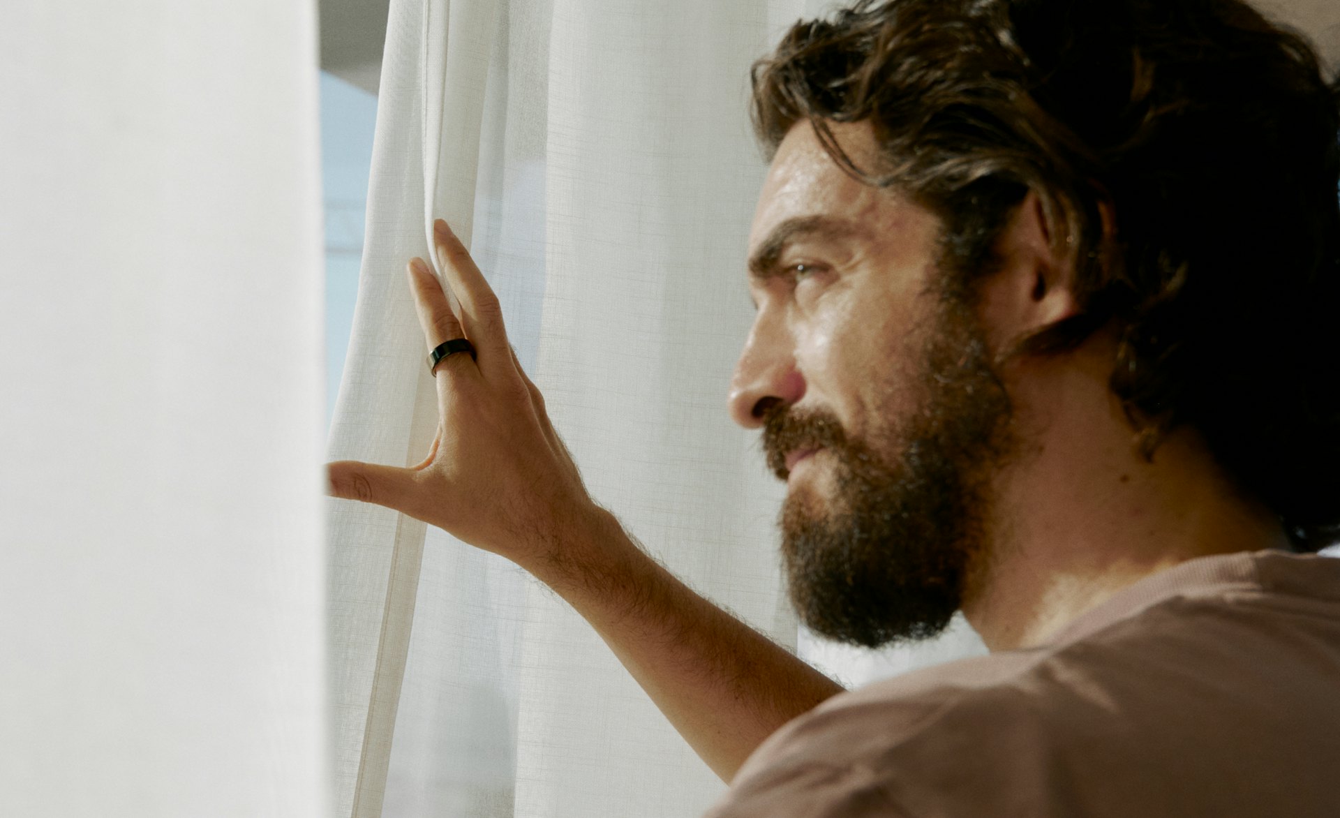 Man wearing an Oura Ring looking out a window